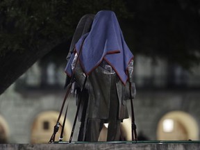 Confederate statutes removed from the University of Texas are secured to a trailer, early Monday morning, Aug. 21, 2017, in Austin, Texas. University of Texas President Greg Fenves ordered the immediate removal of statues of Robert E. Lee and other prominent Confederate figures from a main area of campus Sunday night, saying such monuments have become "symbols of modern white supremacy and neo-Nazism." (AP Photo/Eric Gay)