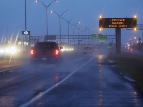 Motorists pass a warning sign  as Hurricane Harvey approaches the Gulf Coast area Friday, Aug. 25, 2017, in Corpus Christi, Texas.  The slow-moving hurricane could be the fiercest such storm to hit the United States in almost a dozen years. Forecasters labeled Harvey a "life-threatening storm" that posed a "grave risk" as millions of people braced for a prolonged battering. (AP Photo/Eric Gay)