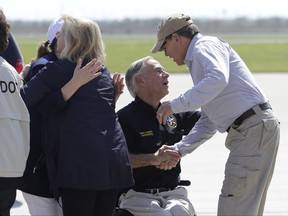 Texas Gov. Greg Abbott, center, greets Energy Secretary Rick Perry, right, as they prepare to visit areas affected by Hurricane Harvey, Thursday, Aug. 31, 2017, in Corpus Christi, Texas. (AP Photo/Eric Gay)