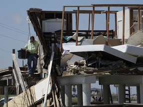 Shane Johnson removes items from a family home destroyed in the wake of Harvey, Tuesday, Aug. 29, 2017, in Rockport, Texas. (AP Photo/Eric Gay)