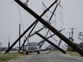 A driver works his way through a maze of fallen utility poles damaged in the wake of Hurricane Harvey, Saturday, Aug. 26, 2017, in Taft, Texas. (AP Photo/Eric Gay)