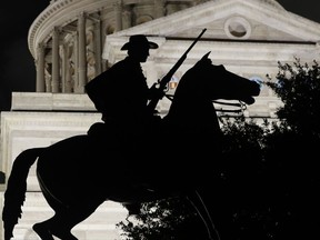 In this Monday, Aug. 21, 2017, photo, the Terry's Texas Rangers cavalry monument, a regiment of Texas volunteers for the Confederate States Army assembled by Colonel Benjamin Franklin Terry in August 1861, is silhouetted against the Texas State Capitol in Austin, Texas. The Civil War lessons taught to American students often depend on where the classroom is, with schools presenting accounts of the conflict that vary from state to state and even district to district. (AP Photo/Eric Gay)