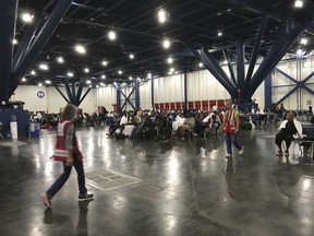 People seek shelter from the aftermath of Hurricane Harvey at the George R. Brown Convention Center in Houston on Sunday, Aug. 27, 2017. Rising floodwaters from the remnants of Hurricane Harvey chased thousands of people to rooftops or higher ground Sunday in Houston, overwhelming rescuers who fielded countless desperate calls for help. (Elizabeth Conley/Houston Chronicle via AP)