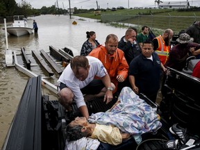 A rescuer moves Paulina Tamirano, 92, from a boat to a truck bed as people evacuate from rising waters from Tropical Storm Harvey, Tuesday, Aug. 29, 2017 in Houston. (Michael Ciaglo/Houston Chronicle via AP)