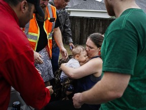 Lauren Durst holds onto her ten-month-old son, Wyatt Durst, as they evacuate from the Savannah Estates neighborhood as Addicks Reservoir nears capacity Tuesday, Aug. 29, 2017, in Houston. ( Michael Ciaglo/Houston Chronicle via AP)