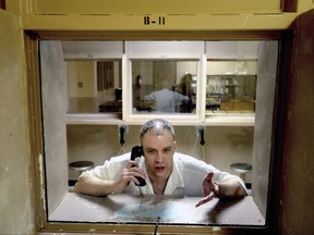 In this Friday, March 18, 2016 photo. inmate Brad Dunn sits behind glass during an interview at the Texas Department of Criminal Justice's Mark W. Michael Unit in Tennessee Colony, Texas. Congress is close to finalizing changes to the nation's emergency dialing system inspired by a girl's struggle to call 911 as her mother lay dying from stab wounds in a Texas hotel room. "Kari's Law" was named after Kari Hunt Dunn, who was slain in 2013 when Brad Dunn, her estranged husband stormed into her hotel room and stabbed her multiple times while her children watched. (Kevin Green/The News-Journal via AP)
