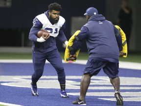 Dallas Cowboys running back Ezekiel Elliott (21) runs a drill during an NFL training camp football practice at the team's headquarters in Frisco, Texas, Monday, Aug. 21, 2017. (AP Photo/LM Otero)