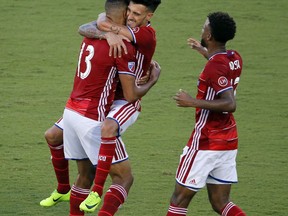 FC Dallas forward Tesho Akindele, left, celebrates with Maximiliano Urruti and Kellyn Acosta, right, after scoring a goal against the Houston Dynamo during the first half of an MLS soccer match, Wednesday, Aug. 23, 2017, in Frisco, Texas. (AP Photo/Tony Gutierrez)