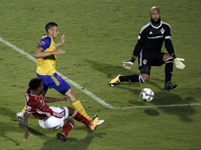 FC Dallas midfielder Kellyn Acosta, bottom left,  shoots as Colorado Rapids's Kortne Ford, top left, and goalie Tim Howard, top right, defend in the second half of an MLS soccer game, Saturday, Aug. 12, 2017, in Frisco, Texas. (AP Photo/Tony Gutierrez)