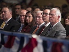 From right, Secretary of State Rex Tillerson, Treasury Secretary Steven Mnuchin, and Attorney General Jeff Sessions look to President Donald Trump as he speaks at Fort Myer in Arlington Va., Monday, Aug. 21, 2017, during a Presidential Address to the Nation about a strategy he believes will best position the U.S. to eventually declare victory in Afghanistan. (AP Photo/Carolyn Kaster)