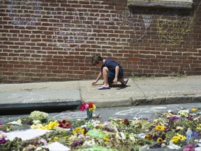 Alexander Holtz, 7, of Ashburn, Va., draws a heart on sidewalk in Charlottesville, Va., Friday, Aug. 18, 2017, near the site where Heather Heyer was killed. Heyer was struck by a car while protesting a white nationalist rally on Saturday Aug. 12. (AP Photo/Cliff Owen)