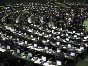 This photo taken on Sunday, Feb. 19, 2017, shows an open session of the Iranian parliament in Tehran, Iran. Iran's parliament voted overwhelmingly Sunday to increase spending on its ballistic missile program and the foreign operations of its paramilitary Revolutionary Guard, chanting "Death to America" in a direct challenge to Washington's newest sanctions on the Islamic Republic. (AP Photo/Vahid Salemi)