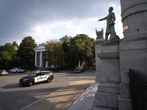 A Richmond Police vehicle pauses in front of the Jefferson Davis Memorial at Davis and Monument Ave. in Richmond, Va., Wednesday, Aug. 16, 2017. Richmond Mayor Levar Stoney has just stated that he thinks the monuments to Confederate figures should be removed from the historic street. (Bob Brown/Richmond Times-Dispatch via AP)