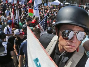 A white nationalist demonstrator with a helmet and shield walks into Lee Park in Charlottesville, Va., Saturday, Aug. 12, 2017.