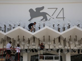 Workers set up lighting at the Cinema Palace ahead of the 74th edition of the Venice Film Festival, at the Venice Lido, Italy, Monday, Aug. 28, 2017. The world's oldest cinema festival, which opens Wednesday, is kicking off the fall cinema season with searing drama, serious glamour and a crop of new movies vying for attention, awards and acclaim. (AP Photo/Domenico Stinellis)