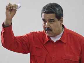 Venezuela's President Nicolas Maduro shows his ballot after casting a vote for a constitutional assembly in Caracas, Venezuela on Sunday, July 30, 2017