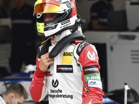Mick Schumacher, son of seven-time F1 world champion Michael Schumacher, walks through the pits prior to driving an exhibition lap ahead of the Belgian Formula One Grand Prix in Spa-Francorchamps, Belgium, Sunday, Aug. 27, 2017. Mick Schumacher will mark the 25th anniversary of his father's maiden Grand Prix victory by demonstrating one of his championship-winning cars ahead of Sunday's race in Belgium. (AP Photo/Geert Vanden Wijngaert)