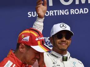 Mercedes driver Lewis Hamilton of Britain, right, stands on the podium with Ferrari driver Sebastian Vettel of Germany after the qualifying session ahead of the Belgian Formula One Grand Prix in Spa-Francorchamps, Belgium, Saturday, Aug. 26, 2017. Lewis Hamilton has secured pole position for the Belgian Grand Prix, equalling Michael Schumacher's record of 68 career poles. (AP Photo/Geert Vanden Wijngaert)
