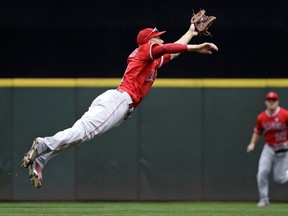 Los Angeles Angels shortstop Andrelton Simmons stretches as he snags a line drive by Seattle Mariners' Jean Segura in the first inning of a baseball game Sunday, Aug. 13, 2017, in Seattle. (AP Photo/Elaine Thompson)
