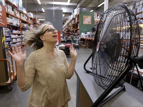 Davi Sobotta holds up her hands as she tries out the last, large tabletop fan available at a Home Depot hardware store ahead of an expected heat wave Tuesday, Aug. 1, 2017, in Seattle. An excessive heat warning for the area began Tuesday afternoon and continues through Friday evening, as unusually hot weather will bring temperatures nearing a peak of 100 degrees on Thursday. (AP Photo/Elaine Thompson)