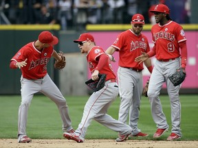 Los Angeles Angels Andrelton Simmons (2), Kole Calhoun, Cliff Pennington and Cameron Maybin (9) celebrate after they defeated the Seattle Mariners in a baseball game Sunday, Aug. 13, 2017, in Seattle. (AP Photo/Elaine Thompson)
