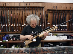 In this Thursday, July 9, 2017 photo, Sergey Solyanik, a software developer for Microsoft and owner of gun retailer Precise Shooter, holds a Anschutz sporting rifle, one of the several firearms for sale at the store in Seattle. The Washington Supreme Court upheld Seattle's so-called "gun violence tax" against a challenge from gun rights groups Thursday, leaving the city as one of the only places in the country that taxes the sale of firearms and ammunition to raise money for gun-violence research. (Sy Bean/The Seattle Times via AP)