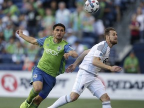 Seattle Sounders' Christian Roldan, left, challenges a Minnesota United player for the ball during an MLS soccer match Sunday, Aug. 20, 2017, in Seattle. (Bettina Hansen/The Seattle Times via AP)
