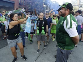 A Seattle Sounders supporter displays a scarf to supporters wearing Portland Timbers jerseys during the traditional March to the Match before an MLS soccer match between the teams Sunday, Aug. 27, 2017, in Seattle. (AP Photo/Ted S. Warren)