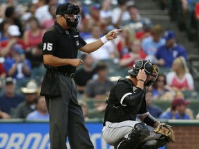 Home plate umpire Tim Timmons (left) wears a white wristband during a Chicago White Sox-Texas Rangers game on Aug. 19.