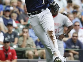 Milwaukee Brewers' Neil Walker makes a play on a ball hit by Cincinnati Reds' Scooter Gennett during the second inning of a baseball game Sunday, Aug. 13, 2017, in Milwaukee. (AP Photo/Morry Gash)