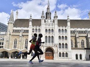 Kenya's Geoffrey Kipkorir Kirui, right, leads Ethiopia's Tamirat Tola past the Guildhall on his way to winning the gold medal in the Men's Marathon during the World Athletics Championships Sunday, Aug. 6, 2017. (AP Photo/Martin Meissner)
