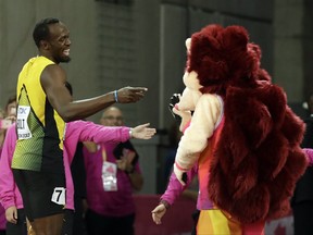 Jamaica's Usain Bolt jokes with mascot Hero the Hedgehog after his men's 100m heat during the World Athletics Championships in London Friday, Aug. 4, 2017. (AP Photo/Matthias Schrader)