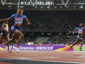 United States' Kori Carter, left, crosses the line to win gold in the women's 400-meter hurdles final during the World Athletics Championships in London Thursday, Aug. 10, 2017. (AP Photo/Matt Dunham)