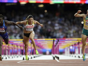 Australia's Sally Pearson, right, crosses the line to win the gold medal in the final of the Women's 100m hurdles during the World Athletics Championships in London Saturday, Aug. 12, 2017. United States' Dawn Harper Nelson, left, took silver and Germany's Pamela Dutkiewicz, center, took bronze. (AP Photo/David J. Phillip)