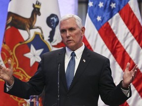 In this Aug. 16, 2017 photo, Vice President Mike Pence takes part in a joint statement with the Chilean president at La Moneda government palace, in Santiago, Chile.   The day after President Donald Trump sparred with reporters on live television over assigning blame for violence at a white supremacist rally, White House aides were stunned, advisers were whispering their frustrations, business allies were cutting public ties with the White House and Trump was out of sight. But Vice President Mike Pence was on message.  At a press conference 5,000 miles away in Santiago, Chile, Pence offered a robust defense of the president, while neither endorsing nor denouncing his words.  (AP Photo/Esteban Felix)