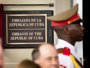 In this July 20, 2015 file photo, a member of the Cuban honor guard stands next to a new plaque at the front door of the newly reopened Cuban embassy in Washington