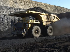 FILE - In this Nov. 15, 2016, file photo, a haul truck with a 250-ton capacity carries coal from the Spring Creek strip mine near Decker, Mont. As President Donald Trump touts new oil pipelines and pledges to revive the nation's struggling coal mines, federal scientists are warning that burning fossil fuels is already driving a steep increase in the United States of heat waves, droughts and floods. (AP Photo/Matthew Brown, File)