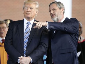 In this photo taken May 13, 2017, President Donald Trump stands with Liberty University President Jerry Falwell Jr. in Lynchburg, Va. Falwell, and an early backer of Trump, said the president had made a "bold truthful statement" about the demonstration. Falwell said the president's remarks were a clear repudiation of white supremacists, Nazis and the Ku Klux Klan. (AP Photo/Steve Helber)