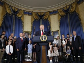 FILE - In this July 24, 2017, file photo, President Donald Trump, accompanied by Vice President Mike Pence, Health and Human Services Secretary Tom Price, and others, speaks about healthcare, in the Blue Room of the White House in Washington. A study by a nonpartisan group says the Trump administration's own actions are triggering double-digit premium increases on individual health insurance policies purchased by millions of consumers. (AP Photo/Alex Brandon, File)
