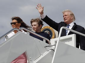 FILE - In this June 30, 2017 file photo, President Donald Trump, first lady Melania Trump and their son Barron Trump board Air Force One at Andrews Air Force Base, Md., en route to Trump National Golf Club in Bedminster, N.J. As President Donald Trump's administration alters some parts of the former first lady's legacy, Mrs. Trump is keeping other parts of it alive, from public policy to high fashion to family ties.  (AP Photo/Carolyn Kaster, File)