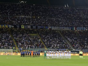 Inter, left, and Fiorentina players observe a minute of silence to honor the victim of Barcelona's attack, prior to the Serie A soccer match between Inter Milan and Fiorentina at the San Siro stadium in Milan, Italy, Sunday, Aug. 20, 2017. (AP Photo/Antonio Calanni)