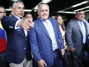 Venezuelan Constitutional assembly delegate and Leader of Venezuela's ruling socialist party Diosdado Cabello, center, accompanied by fellow delegate Pedro Carreno, left, leaves the General Prosecutors office in Caracas, Venezuela, Wednesday, Aug. 16, 2017. Cabello is alleging that the husband and close aides of ousted chief prosecutor Luisa Ortega ran a multi million dollar extortion ring. (AP Photo/Ariana Cubillos)