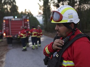 In this photo taken on Thursday, Aug. 10 2017, Hugo Simoes talks on the radio while coordinating a group of volunteer firefighters from Lisbon helping fight a forest fire near the village of Aldeia do Monte outside Abrantes, central Portugal. Almost all of the 2,000 Portuguese firefighters at a weeklong wildfire that killed more than 60 people this summer had something in common apart from the acute danger they faced: they were doing it for no pay and with equipment bought with public donations. More than 90 percent of Portugal's around 30,000 firefighters are volunteers. (AP Photo/Armando Franca)