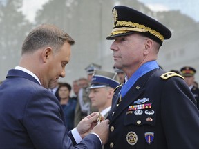 Lieutenant General Ben Hodges, the US Army commander in Europe, right, is decorated with the Commander's Cross with a Star of the Order of Merit by Polish President Andrzej Duda, left, prior to the yearly military parade celebrating the Polish Army Day, in Warsaw, Poland, Tuesday, Aug. 15, 2017. (AP Photo/Alik Keplicz)