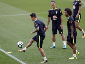Brazil's Philippe Coutinho, left, practices as teammates Firmino, center, and Marcelo look on during a training session in Porto Alegre, Brazil, Tuesday, Aug. 29, 2017. Brazil will face Ecuador in a 2018 World Cup qualifying soccer match on Aug. 31. (AP Photo/Andre Penner)