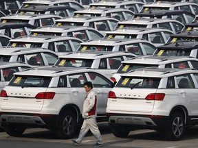 FILE - In this Feb. 19, 2017, file photo, a worker walks past Haval SUV models parked outside the Great Wall Motors assembly plant in Baoding in north China's Hebei province. Chinese SUV maker Great Wall Motors is considering making a bid to acquire Fiat Chrysler's Jeep unit, two employees of the Chinese company said Monday, Aug. 21, 2017 in an ambitious new move for the country's fast-growing domestic auto brands. Great Wall has yet to make a formal announcement of its interest in Jeep but a possible acquisition would be in line with chairman Wang Jianjun's goal, announced in February, of becoming the top specialty SUV producer by 2020. (AP Photo/Andy Wong, File)