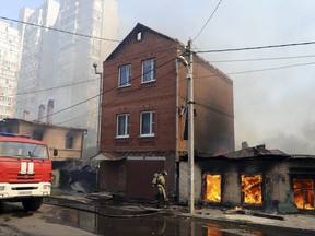 A firefighter works to put out a blaze at houses in Rostov-on-Don, Russia, Monday, Aug. 21, 2017. Hundreds of firefighters backed by helicopters were deployed to extinguish the blaze that engulfed dozens of buildings. (AP Photo)