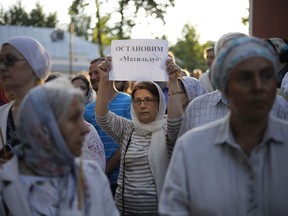 In this photo taken on Tuesday, Aug. 1, 2017, an Orthodox protester holds up a sign reading "Stop Matilda" during a protest against the release of a movie depicting a liaison of Russia's last czar in Moscow, Russia. Russia's Culture Ministry says that a controversial historical film about the last Russian czar's affair with a ballerina has been cleared for release. "Matilda," which is about Nicholas II's relationship with Matilda Kshesinskaya, has drawn virulent criticism from some Orthodox believers and hard-line nationalists, who see it as blasphemy against the emperor, glorified as a saint by the Russian Orthodox Church. (AP Photo/Alexander Zemlianichenko)