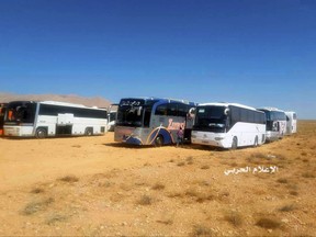 This photo provided on Monday, Aug 28, 2017 by the government-controlled Syrian Central Military Media, shows buses gathering before a planned evacuation of Islamic State group militants, in the mountainous region of Qalamoun, Syria. The remains of eight Lebanese soldiers kidnapped by the Islamic State group three years ago were located Sunday, a senior Lebanese official said, in a negotiated deal that followed a military offensive to drive the militants out of the border area with Syria. (Syrian Central Military Media, via AP)
