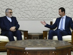 FILE - In this Jan. 4, 2017 file photo, released by the Syrian official news agency SANA, Syrian President Bashar Assad, right, meets with Alaeddin Boroujaerdi, who leads the foreign policy and national security portfolios at Iran's top Shura Council, at the Syrian presidential palace, in Damascus, Syria. Thousands of Iranian-backed fighters in Syria's desert central region are advancing east, bringing Tehran closer to its goal of securing a corridor from its border through Iraq all the way to the Mediterranean that would give it unhindered land access to its allies in Syria and Lebanon for the first time. (SANA via AP, File)